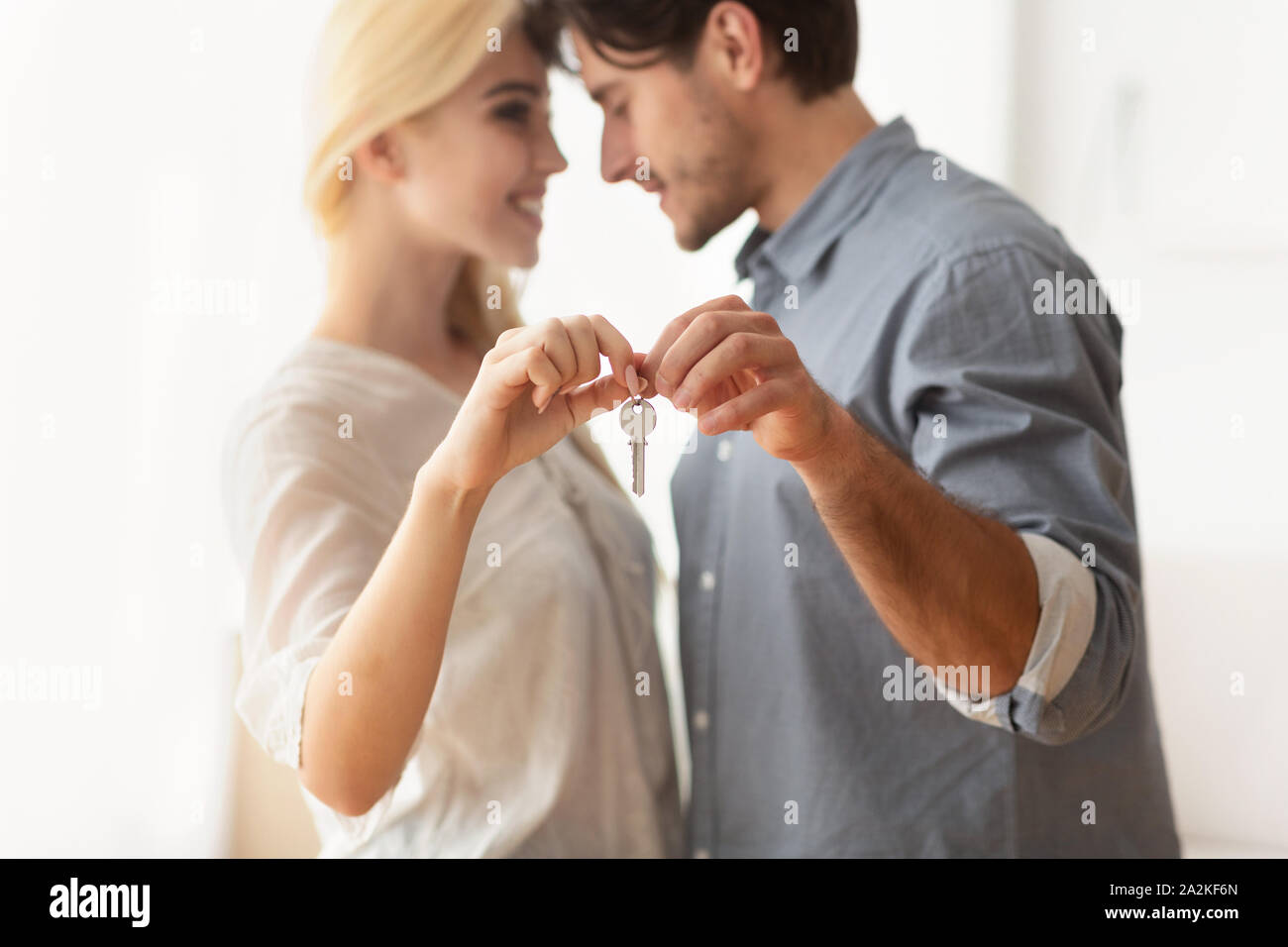 Il marito e la moglie Holding nuova chiave piatta e abbracciando Indoor Foto Stock