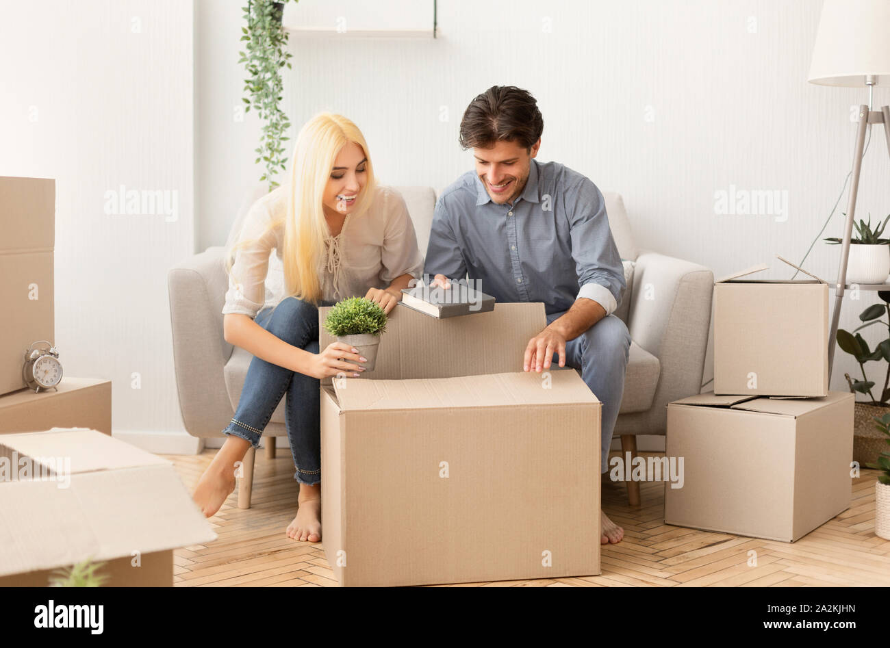 Giovane uomo e donna cose di imballaggio in contenitori per il trasloco  indoor Foto stock - Alamy