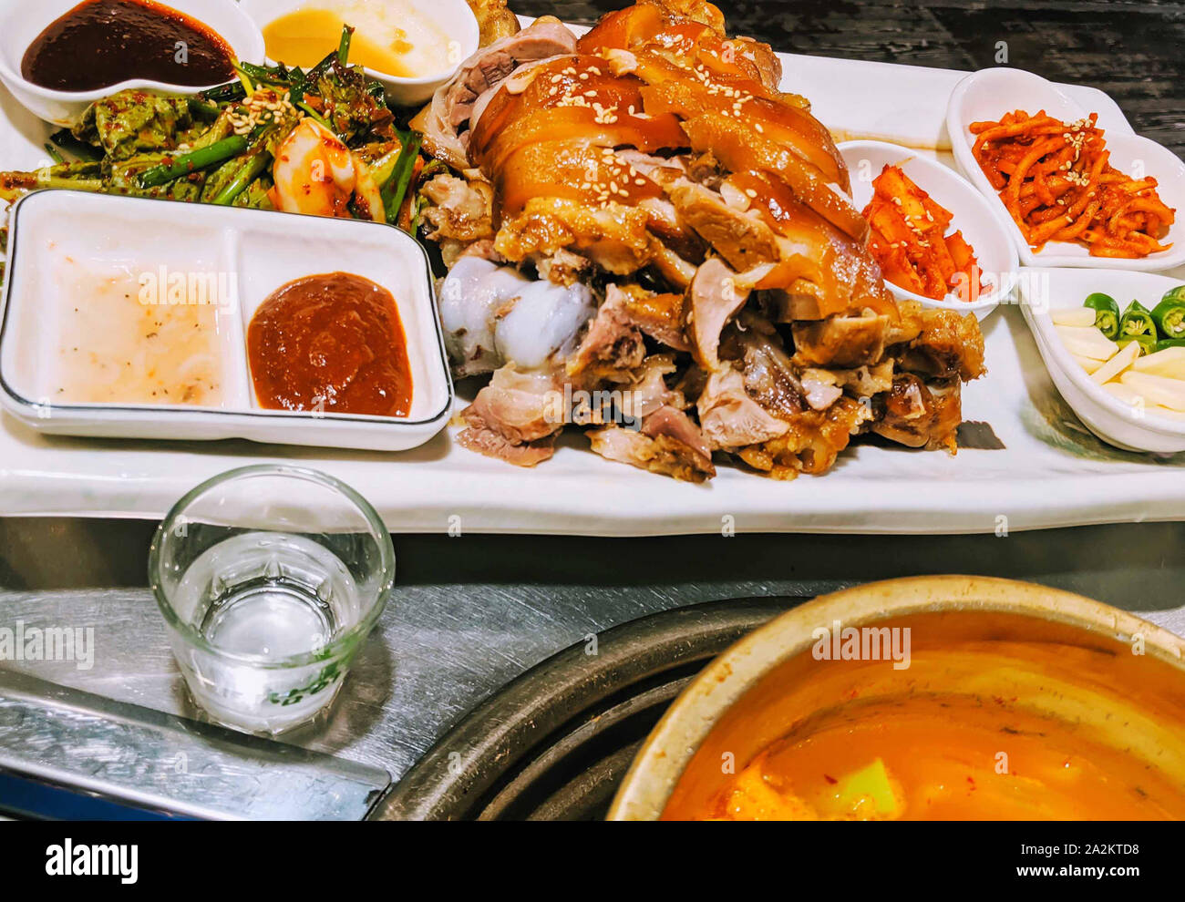 Carne di maiale alla griglia con una pelle dorata con kimchi e varie spezie per una salsa. Foto Stock