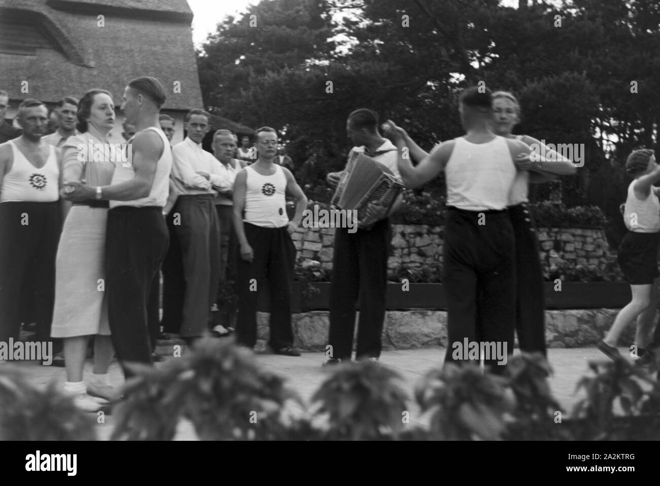 Musik und Tanz vor Waldhütten des KdF Sportheim Belzig in der Mark Brandenburg, Deutschland 1930er Jahre. La gente di cantare e ballare nella parte anteriore dei rifugi forestali presso il club sportivo a Belzig nel Brandeburgo, Germania 1930s. Foto Stock