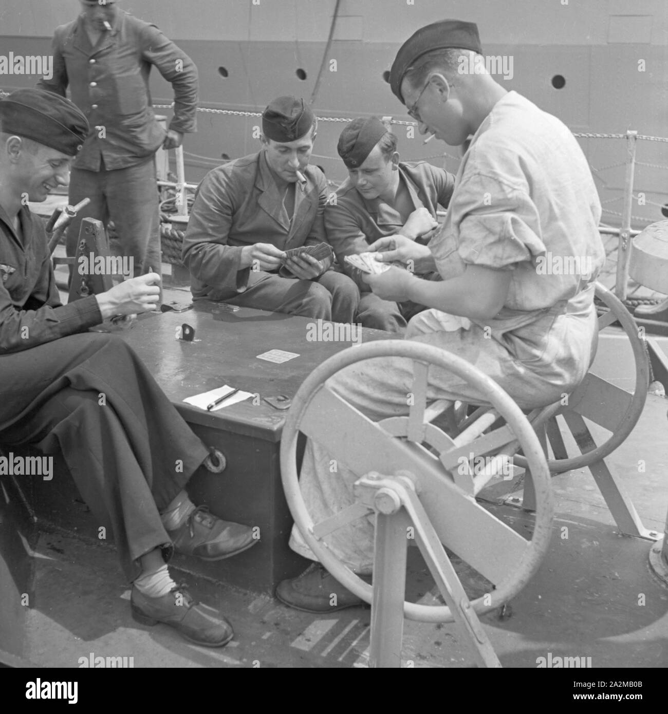 Original-Bildunterschrift: Freizeit des Matrosen: Matrosen beim Kartenspiel un deck an Bord eines Torpedoboots, Deutschland 1940er Jahre. Sailor's: il tempo libero giocando a carte sul ponte di una torpediniera, Germania 1940s. Foto Stock