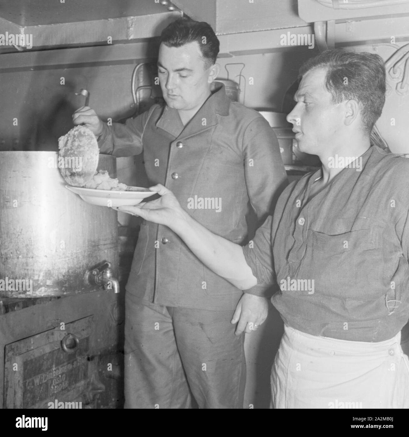 Original-Bildunterschrift: Dienst des Matrosen: Essenfassen in der Kombüse an Bord eines Torpedobootes, Deutschland 1940er Jahre. Sailor's duty: chow tempo presso la cucina su una torpediniera, Germania 1940s. Foto Stock