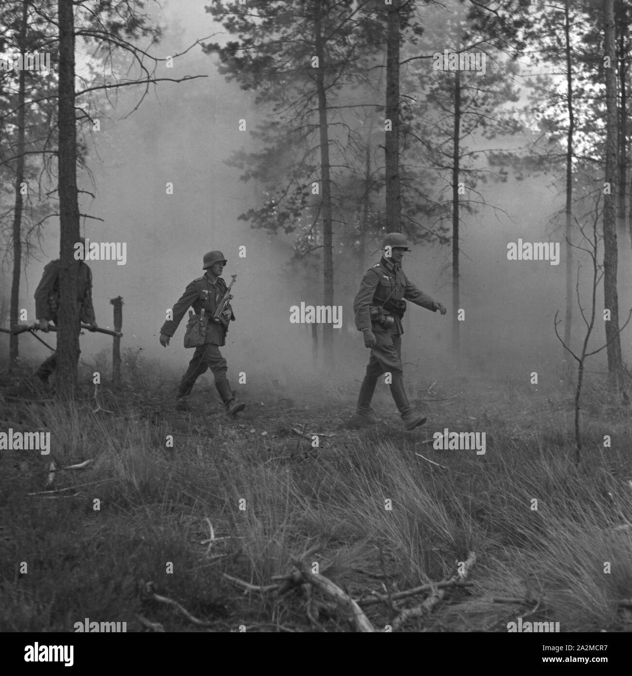 Original-Bildunterschrift: Ein Pionier Stoßtrupp geht uim Schutz der Morgendämmerung gegen die feindlichen Stellungen vor, er"führt, Sprengladungen, Flammenwerfer und Handwaffen aller Art mit sich, Deutschland 1940er Jahre. Coperta dalla nebbia mattutina i soldati alla ricerca di postazioni ostili. Essi prendono flamethrowers ed esplosivi li merita, Germania 1940s. Foto Stock