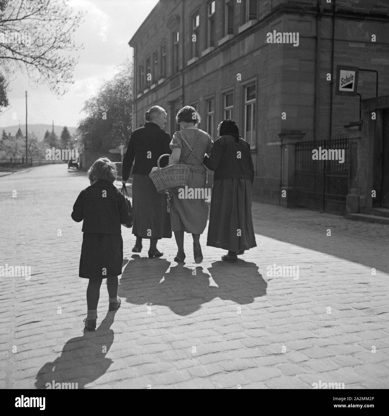 Frauen und ein tipo gehen un einer Schule vorbei, Deutschland 1930er Jahre. Donne e un bambino camminare vicino a una scuola, Germania 1930s. Foto Stock