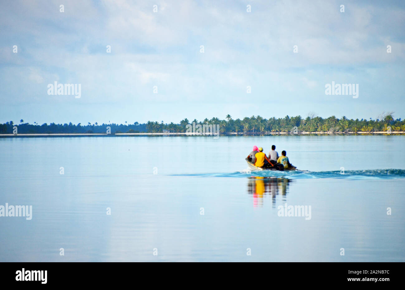 Una piccola barca da pesca espone attraverso la laguna dal villaggio di Tukuhora su Anaa Atoll, Polinesia Francese Foto Stock