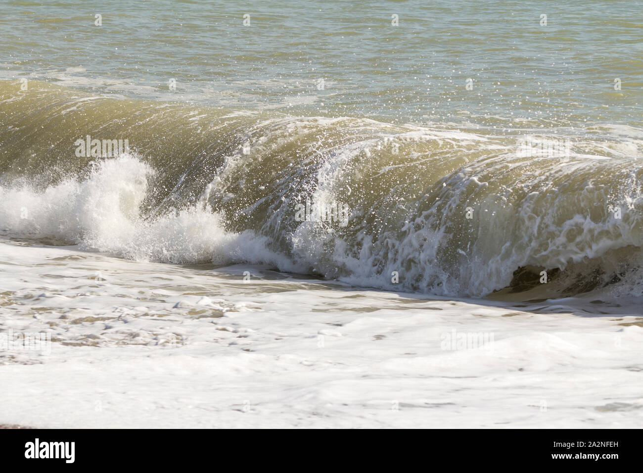 La laminazione di onde a schiantarsi sulla spiaggia azione freeze immagine di navigare in acque bianche potenza di schiuma di edificio e schiantarsi marea onde autunno seascape immagine. Foto Stock