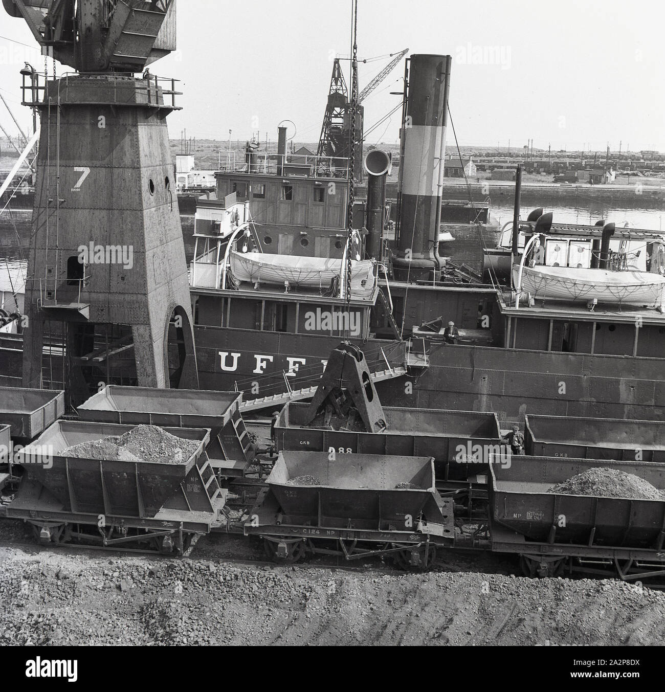 Anni '1950, storico, London Docks, una nave a vapore con banchina ormeggiata a imbuto con vagoni ferroviari carichi di merci, Londra, Inghilterra, Regno Unito. Foto Stock
