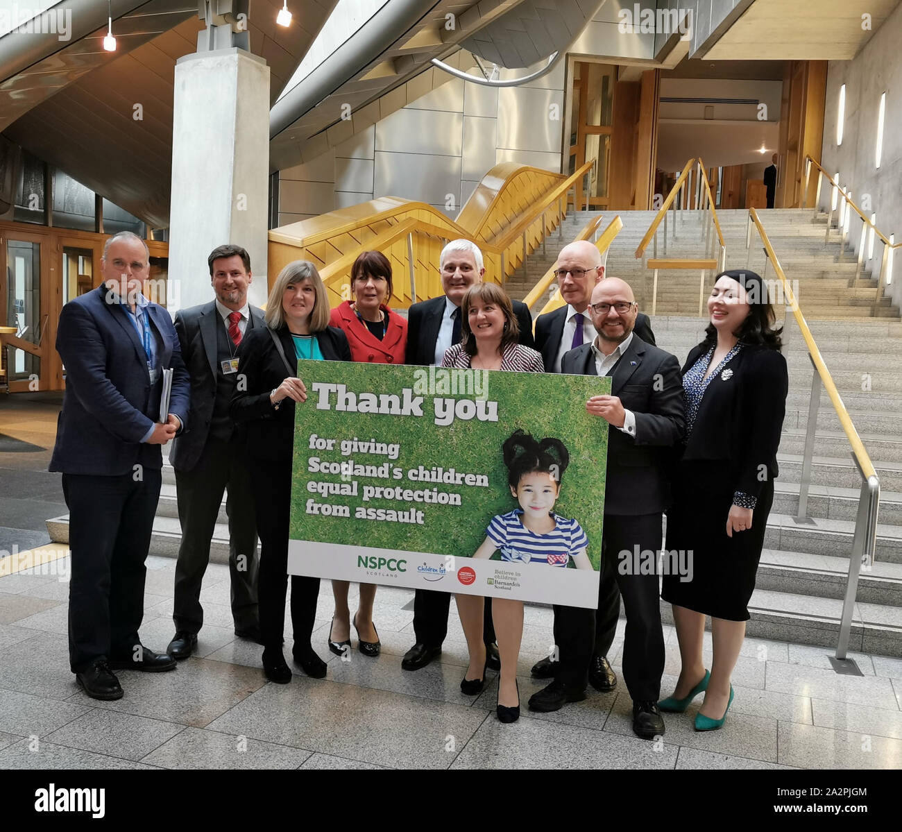 MSPs in parlamento scozzese di Edimburgo, celebrando il passaggio dei bambini (eguale tutela da assalto) (Scozia) Bill, il che significa che un divieto di smacking dei bambini in Scozia. Foto Stock