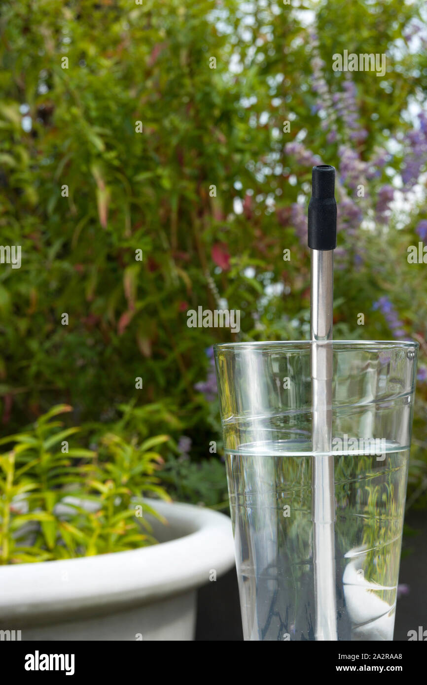 Inossidabile riutilizzabili in plastica acciaio libero cannuccia in uso in un bicchiere di acqua, STATI UNITI D'AMERICA Foto Stock