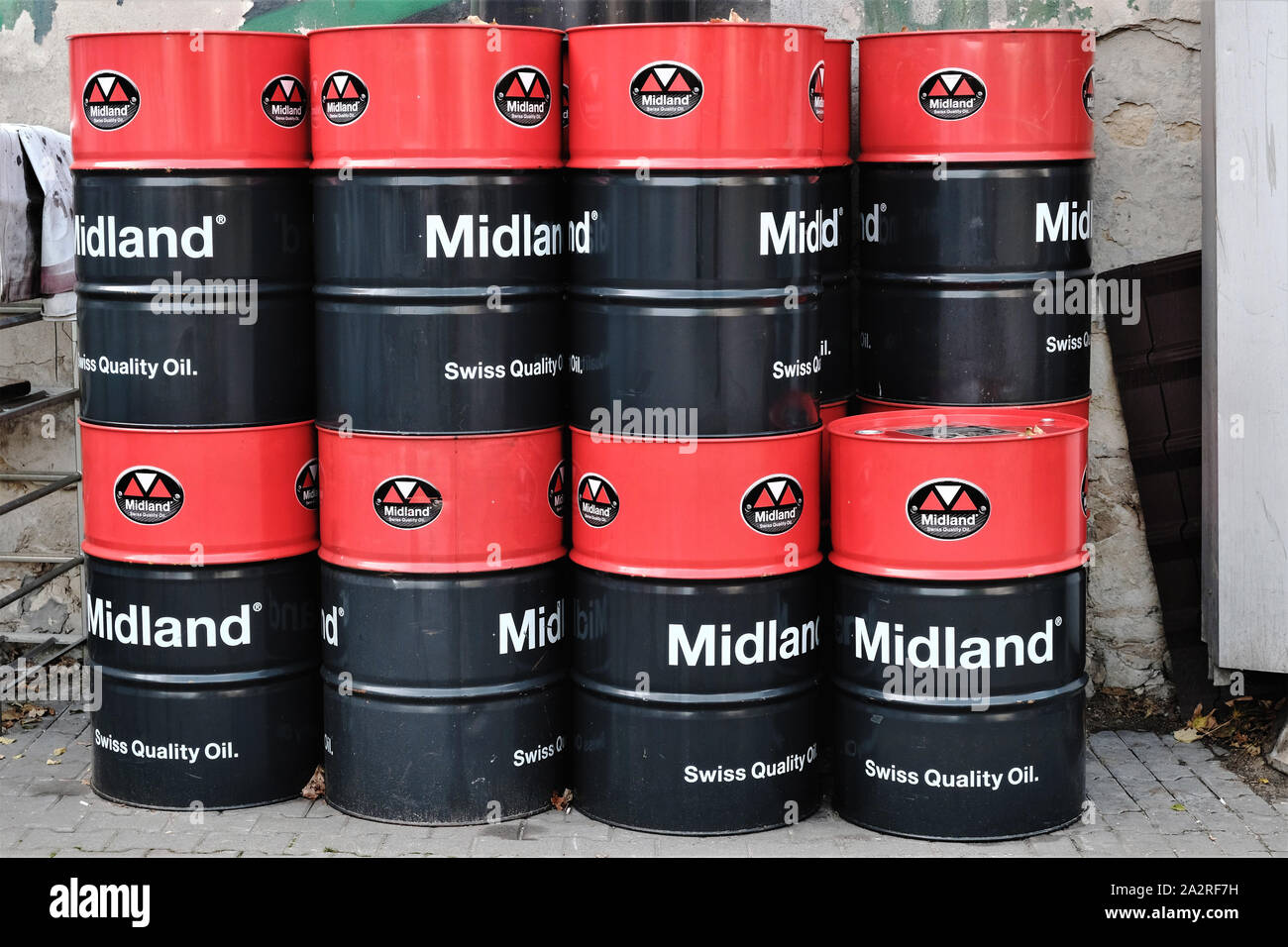 Barili di 'Midland qualità svizzera'olio lubrificante motore impilati in cantiere di un servizio garage. Foto Stock
