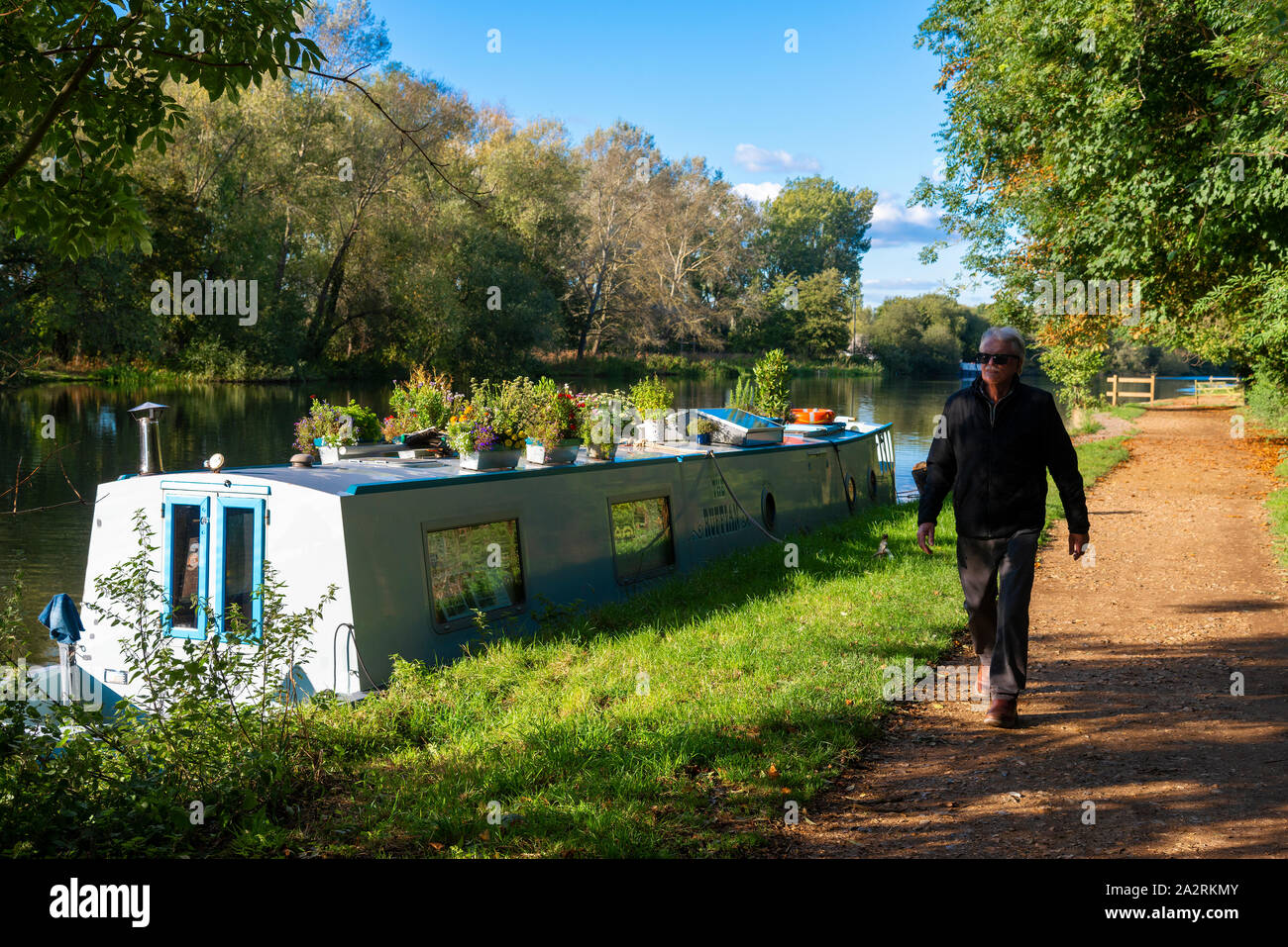 Uomo a camminare lungo il Tamigi percorso su un pomeriggio autunnale accanto al Fiume Tamigi a Sonning on Thames, Berkshire, Inghilterra, Regno Unito Foto Stock