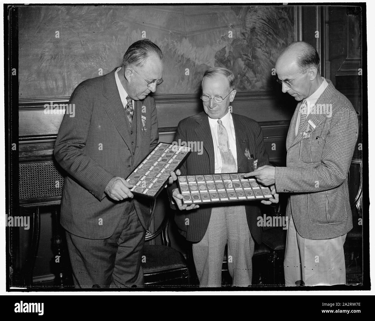 Raro di vecchie monete sul display alla convenzione di numismatica. Washington, D.C. Agosto 24. La raccolta delle prime monete coniate in America, risalente come presto come 1652, era invidiato dai collezionisti di monete provenienti da tutto il paese come hanno frequentato la American Convenzione Numismatica qui oggi. La collezione è di proprietà di T. James Clarke, (centro) Presidente della American Associazione numismatica, che sta mostrando loro di F.E. Hodge ha (sinistra) e C. Shirley Leachman. Le monete sono fatte di argento. 8/24/37 Foto Stock