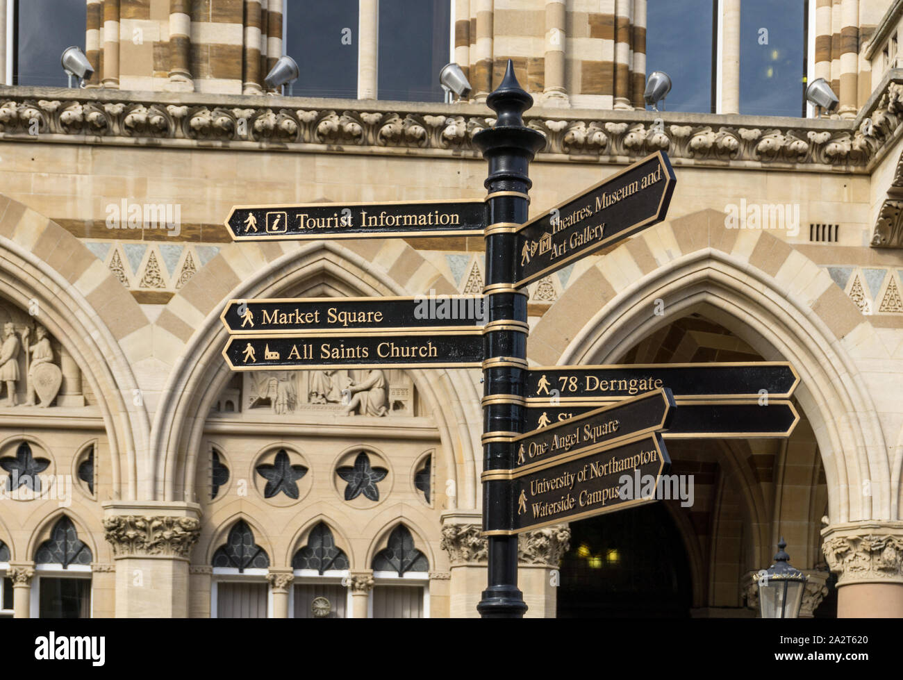 Cartello a dare indicazioni per varie attrazioni turistiche, con la Guildhall in background, Northampton, Regno Unito Foto Stock