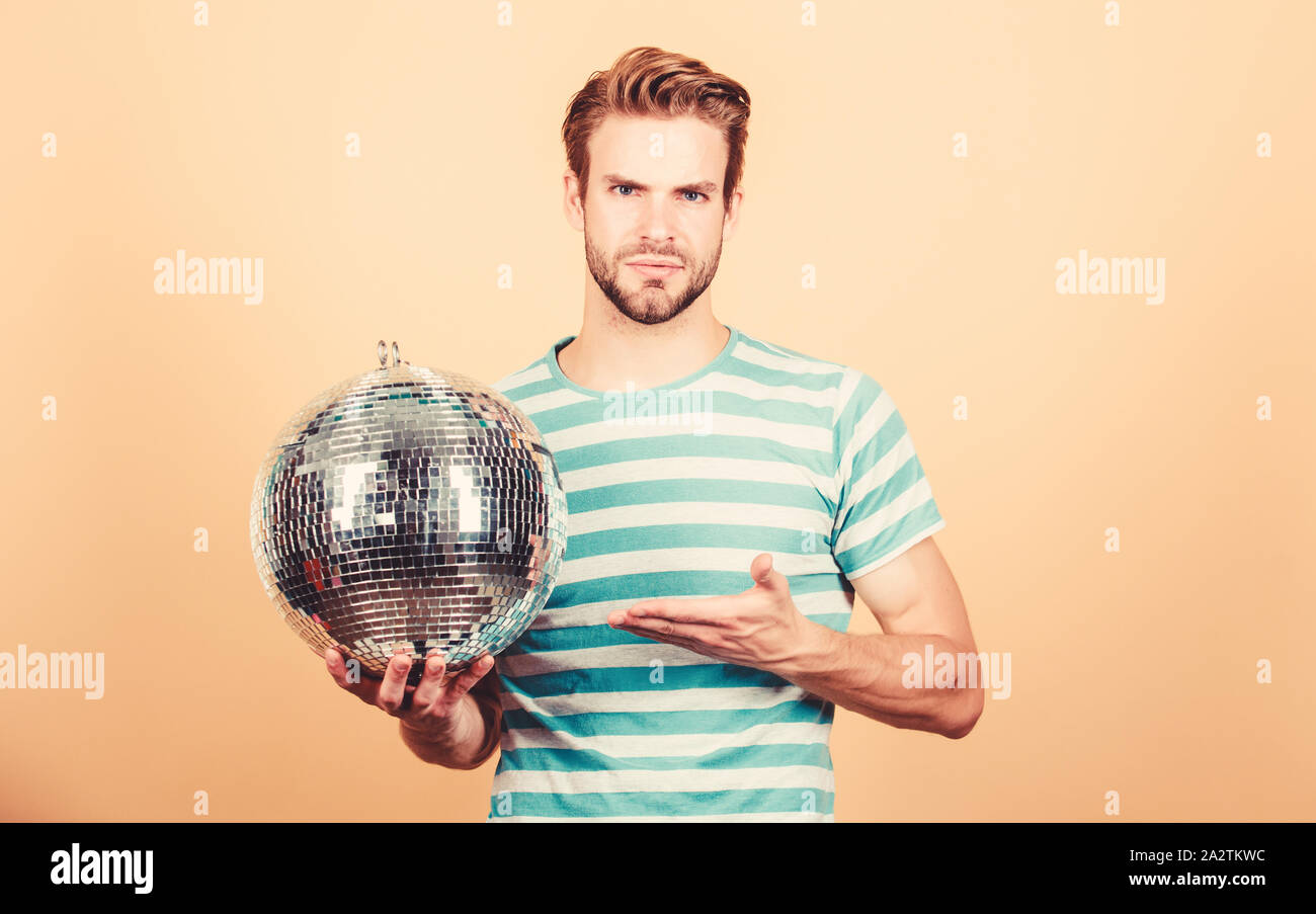 Allegro dj uomo. Come circa la parte. Uomo bello tenere palla da discoteca. Migliaia di minuscoli specchi che riflettono la creazione delle luci di atmosfera da discoteca. Danze da discoteca night club. Musica retrò. Ragazzo che vi invitano a parte. Foto Stock
