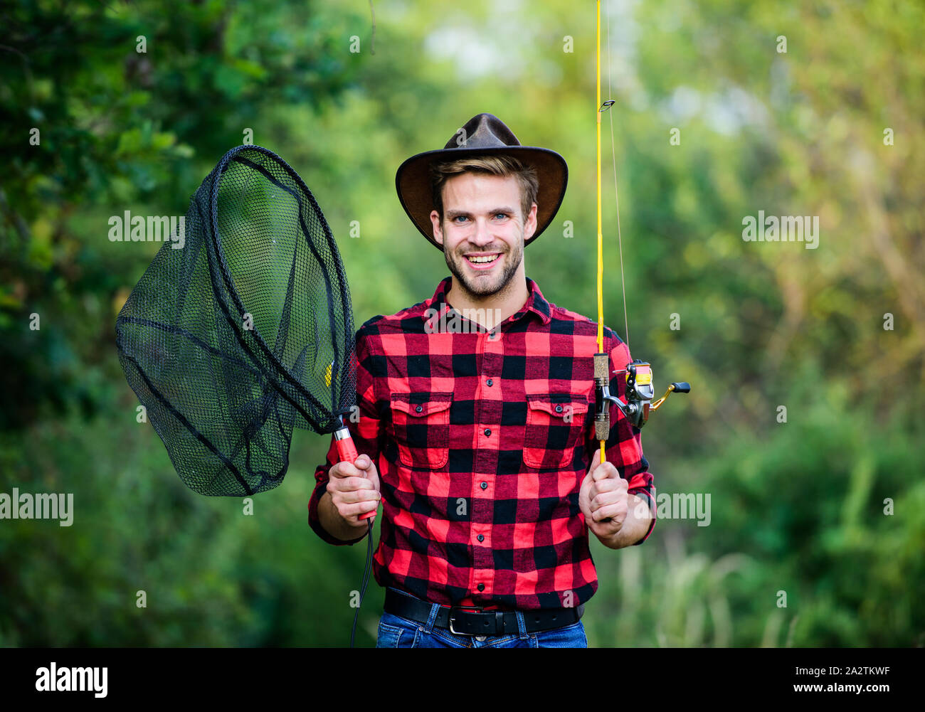 Andando a pesca. pescatore con canna da pesca. uomo felice nel cappello da  cowboy western ritratto. In stile vintage uomo. Wild West retrò cowboy.  pesca con la mosca. l uomo camicia a