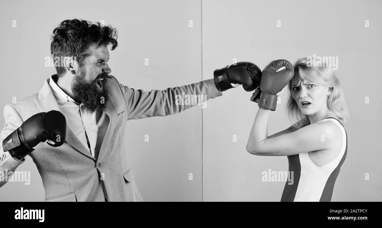Matura in amore competere nel pugilato. Maschi e femmine di boxer combattimenti a guanti. Concetto di dominazione. Battaglia di genere. Sesso parità di diritti. La parità tra i sessi. Uomo abito formale e atletico donna boxe lotta. Foto Stock