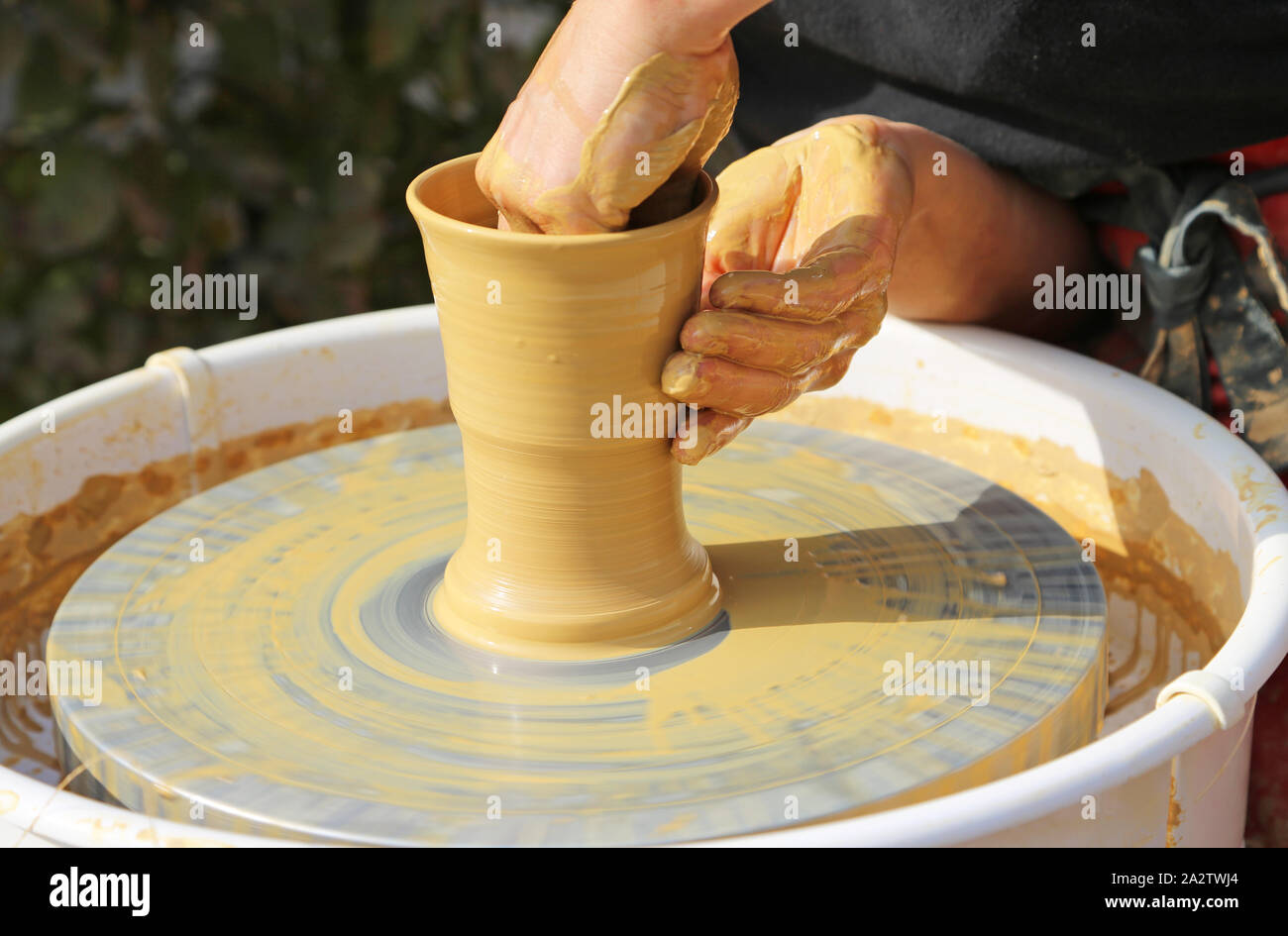 Mani formando una tazza su una ruota di vasai Foto Stock