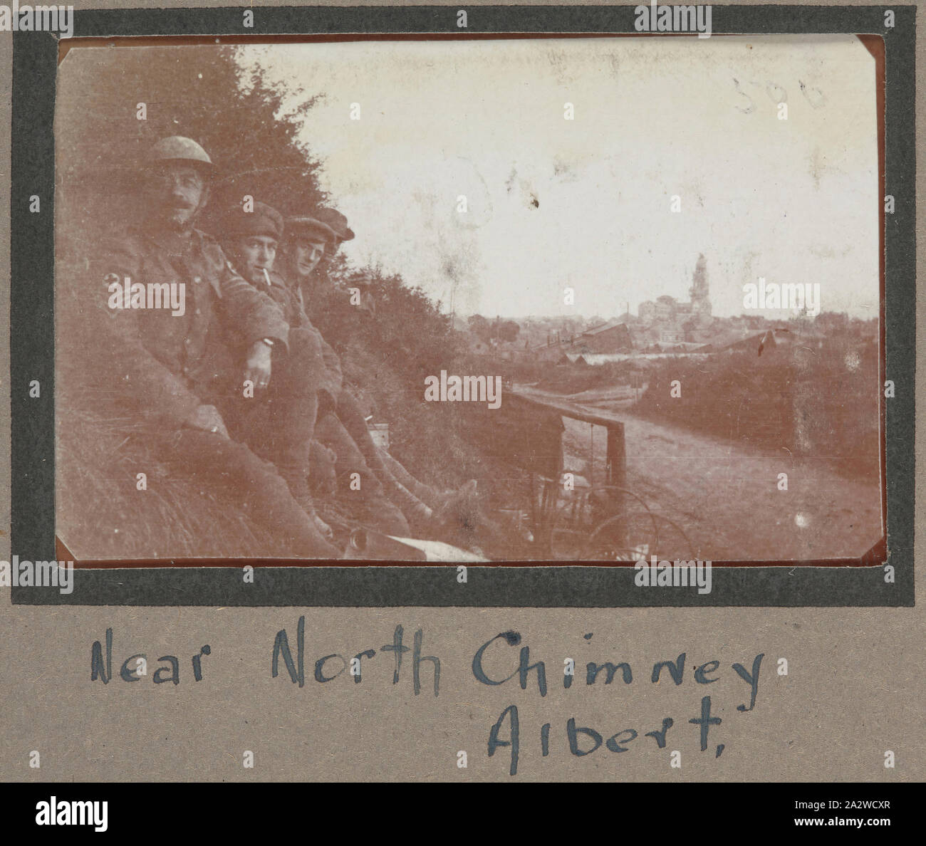 Fotografia - 'vicino al camino del Nord, Albert', Francia, sergente John Lord, guerra mondiale I, 1916-1917, stampa fotografica in bianco e nero che mostra quattro soldati seduti su una piccola collinetta erbosa con la città di Albert in background. Capi di abbigliamento di questi quattro soldati sono indossando indica che essi sono parte del campo ambulanza e molto probabilmente in base all'Albert. La sede centrale della divisione australiana è stata temporaneamente in base all'Albert a causa dei pesanti combattimenti che hanno avuto luogo nelle vicinanze Foto Stock
