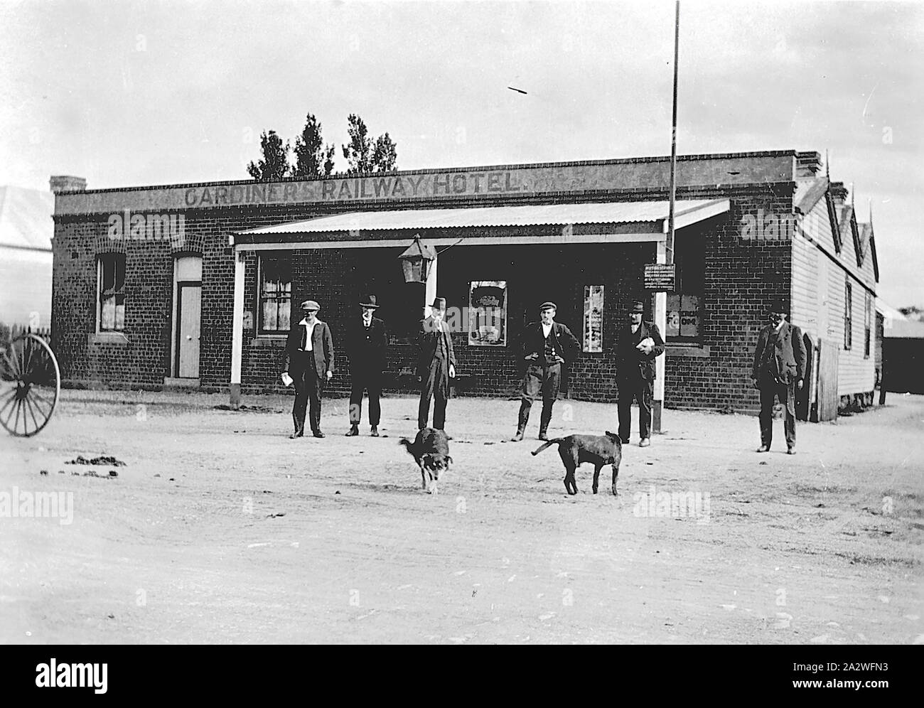 Negativo - Meredith, Victoria, circa 1920, un gruppo di uomini e due cani di fronte Gardiner's Railway Hotel Foto Stock