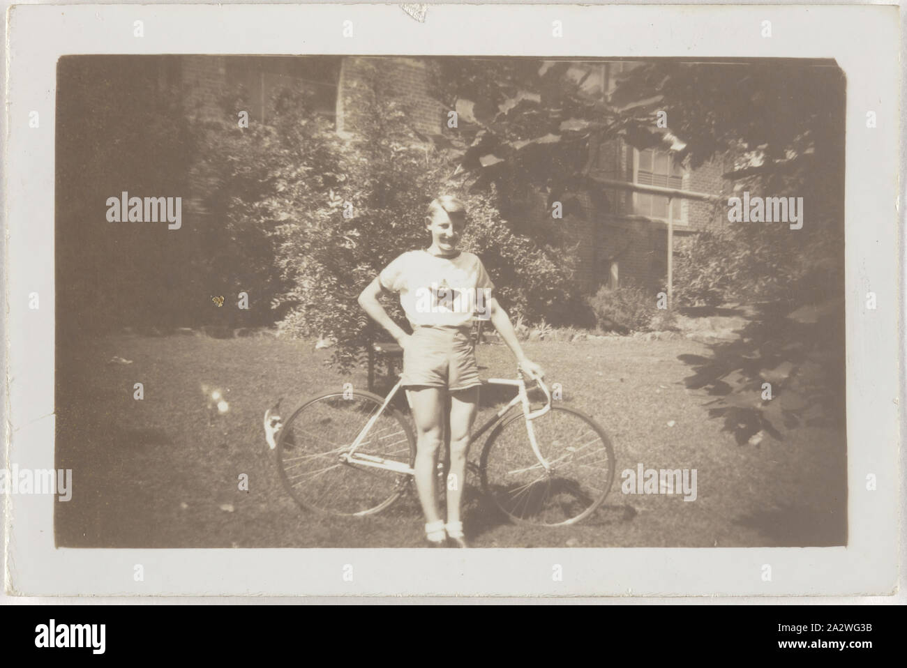 Fotografia digitale - Harry Clarke con la bicicletta, fabbrica, Kodak Australasia Pty Ltd, Abbotsford, Victoria, primi anni quaranta, fotografia in bianco e nero di Harry Clarke con la sua bicicletta nella zona del giardino del Kodak Australasia Pty Ltd sito di fabbrica in Abbotsford, nei primi 1940s. Questa fotografia mette in evidenza il punto di intersezione tra il mercato interno e per quello industriale si è verificato che su questo sito dopo la II Guerra Mondiale, che era un singolare ed unica esperienza in Kodak storia di fabbricazione. Harry Clarke era un ragazzo giovane Foto Stock