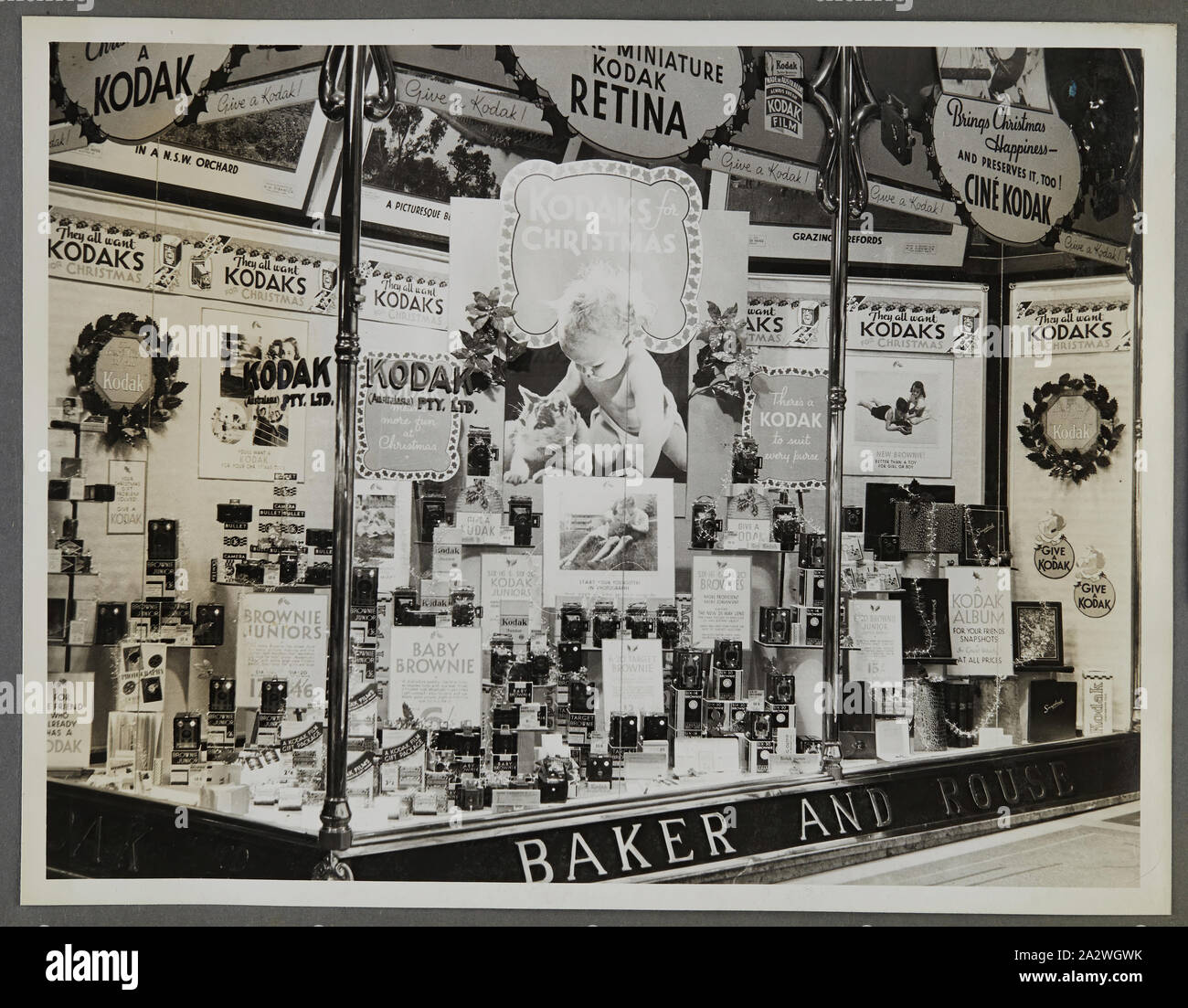 Fotografia - Kodak, Shopfront Display, 'Kodaks per Natale', circa 1934-1936, display Shopfront 'Kodaks per Natale" che mostra le telecamere, fotografie, accessori fotografici e attrezzature. Uno dei cinquanta-sei fotografie in un album che ritrae Kodak Australasia Pty Ltd shop finestra anteriore visualizza dal mid-1930s. Windows generalmente prodotto in vetrina promozioni per film o telecamere, così come le mostre fotografiche per attirare la folla al negozio. Mostre featured mt Foto Stock