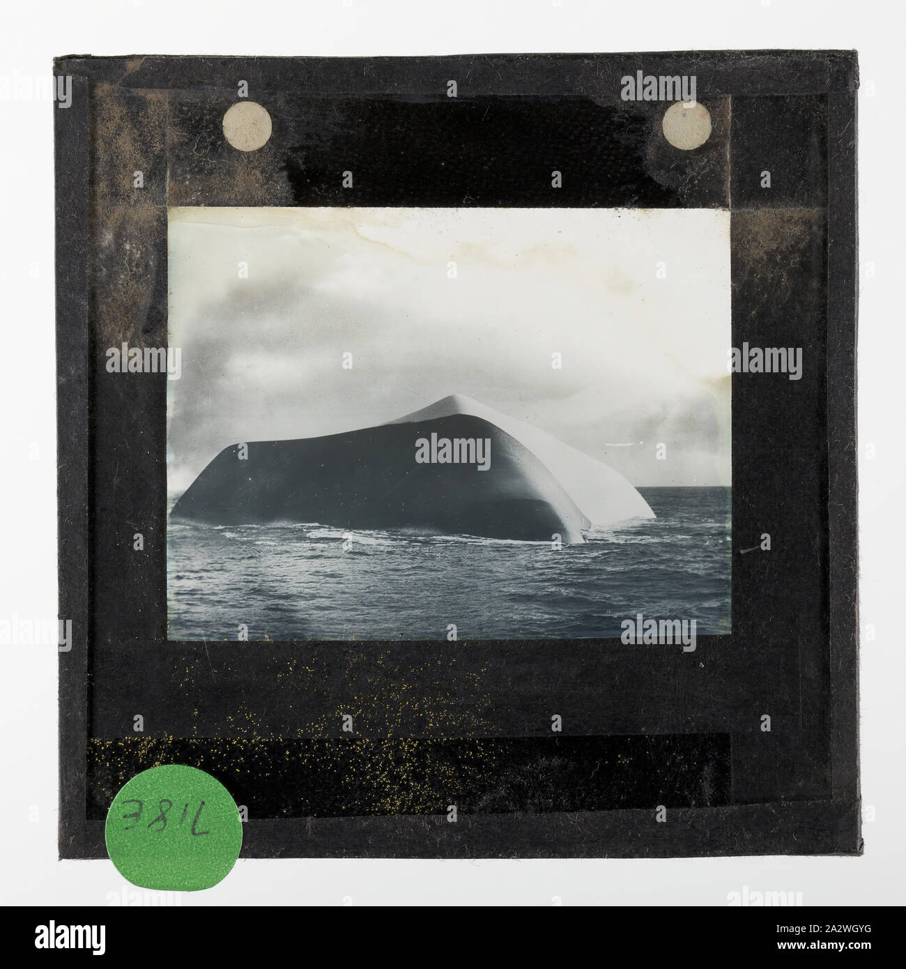 Lantern Slide - un Black & White Iceberg, BANZARE Voyage 1, Antartide, 1929-1930, Lanterna della slitta di un bianco e nero iceberg. Nero bergs è apparso il nero a una distanza, ma da vicino sono stati trovati per essere fatta di traslucido verde bottiglia, mare di ghiaccio embedded con ciottoli e sporcizia. Uno di 328 immagini in vari formati tra cui opere, fotografie, vetro di negativi e diapositive lanterna Foto Stock