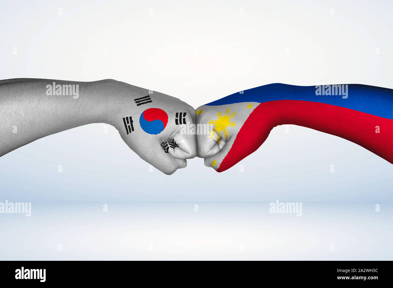 Bump pugno di Filippino e sud coreani bandiere. Due mani con bandiere dipinte delle Filippine e Corea del Sud bandiera fist bumping come un simbolo di unità. Foto Stock