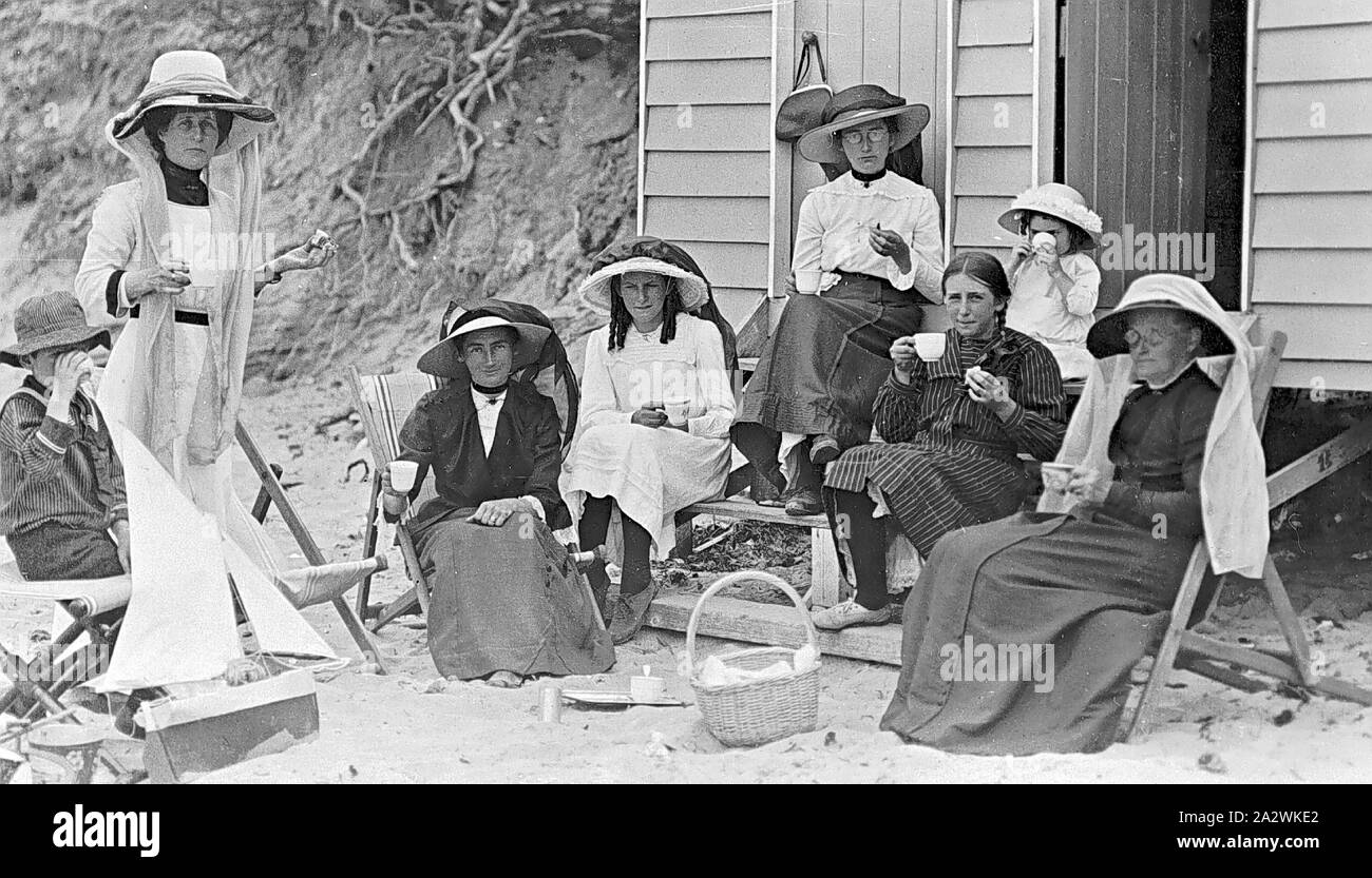 Negativo - gruppo di donne e bambini Picnicing sulle sedie a sdraio di  fronte delle scatole di balneazione, punto Lonsdale, Victoria, 1914, un  gruppo di donne e bambini su un picnic sulla