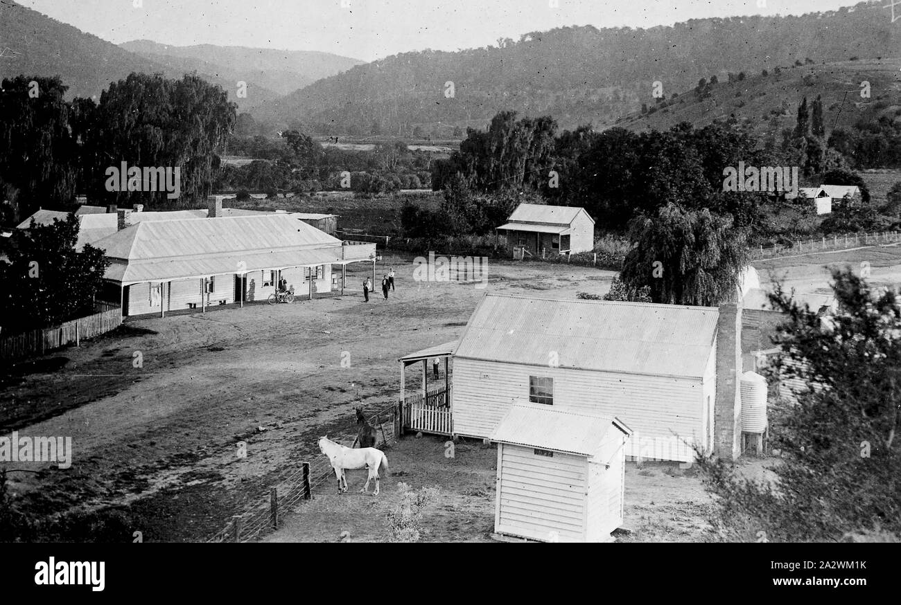 Negativo - Bridge Hotel & stazione di polizia, Dargo, Victoria, circa 1916, Vista delle miniere d'oro e di agricoltura township di Dargo in Gippsland, Victoria, guardando verso sud-est. In primo piano è il weatherboard stazione di polizia a cavallo paddock e weatherboard il collegamento meccanico al nearside. Sul lato opposto della strada sterrata è un grande weatherboard hotel occupa un edificio ad angolo con verande su entrambe le facciate e un piccolo cottage weatherboard opposto. In Foto Stock