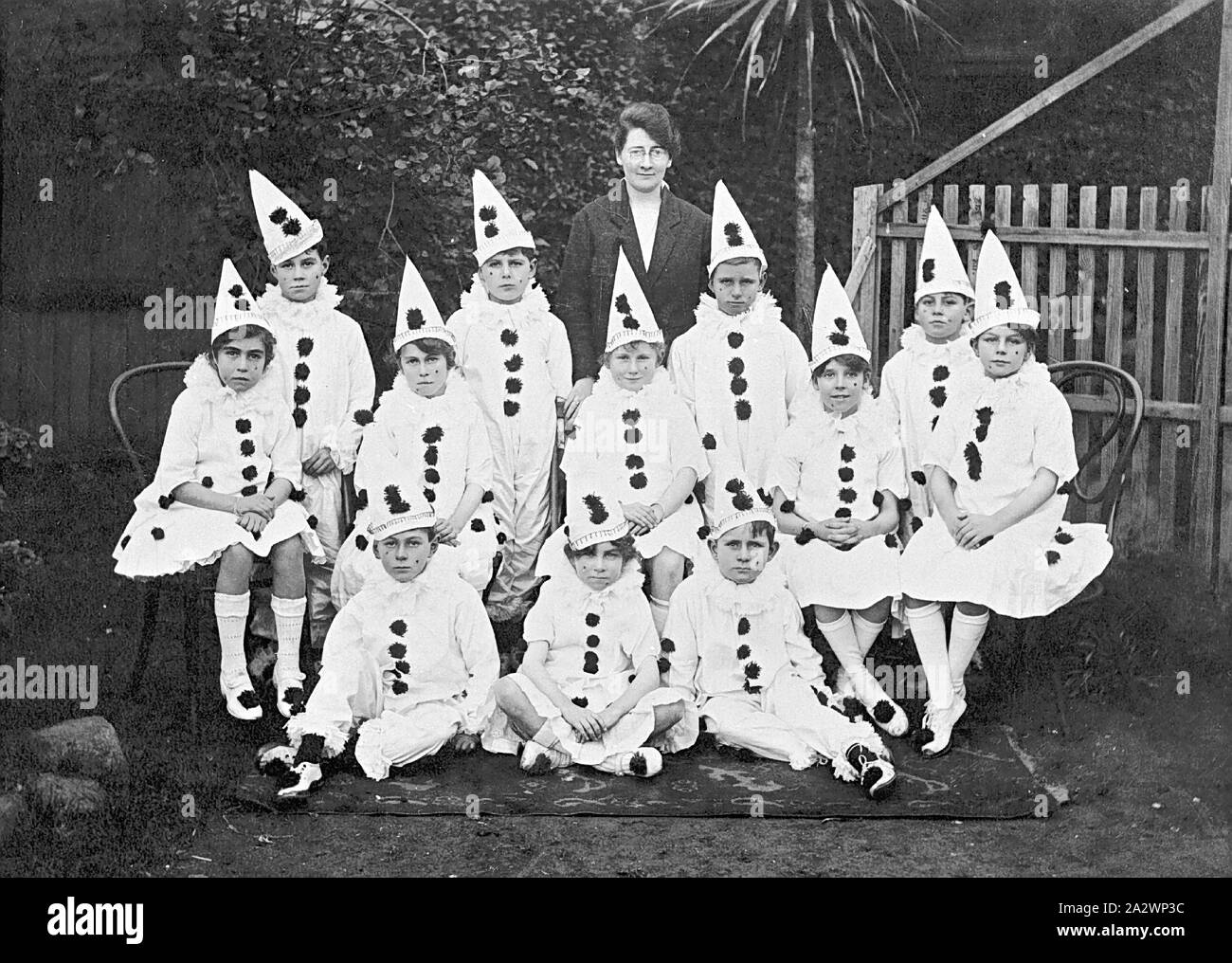 Negativo - Thornbury, Victoria, circa 1920, gli alunni in Pierrot vestito per una pantomima. Il loro insegnante sorge dietro di loro Foto Stock