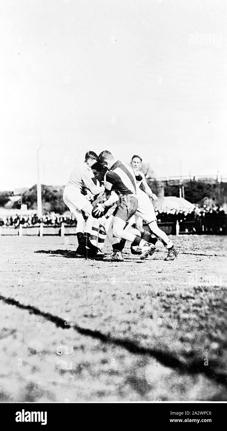 Negativo - Ballarat District (?), Victoria, circa 1925, i giocatori in un australiano regole del gioco del calcio. I pali getta un ombra in primo piano Foto Stock