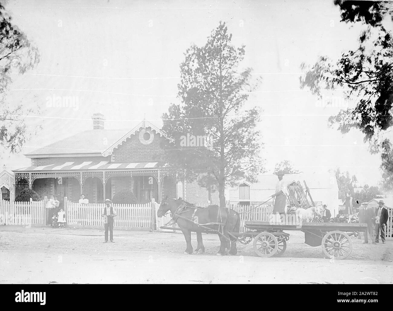 Negativo - Bendigo, Victoria, circa 1895, una famiglia nella foto al di fuori della loro casa, che è il doppio con la facciata in mattoni, stile Federazione. Annessi e giardini da entrambi i lati e la parte posteriore della casa. Vi è un cavallo disegnato a dray in strada, con driver e merci Foto Stock