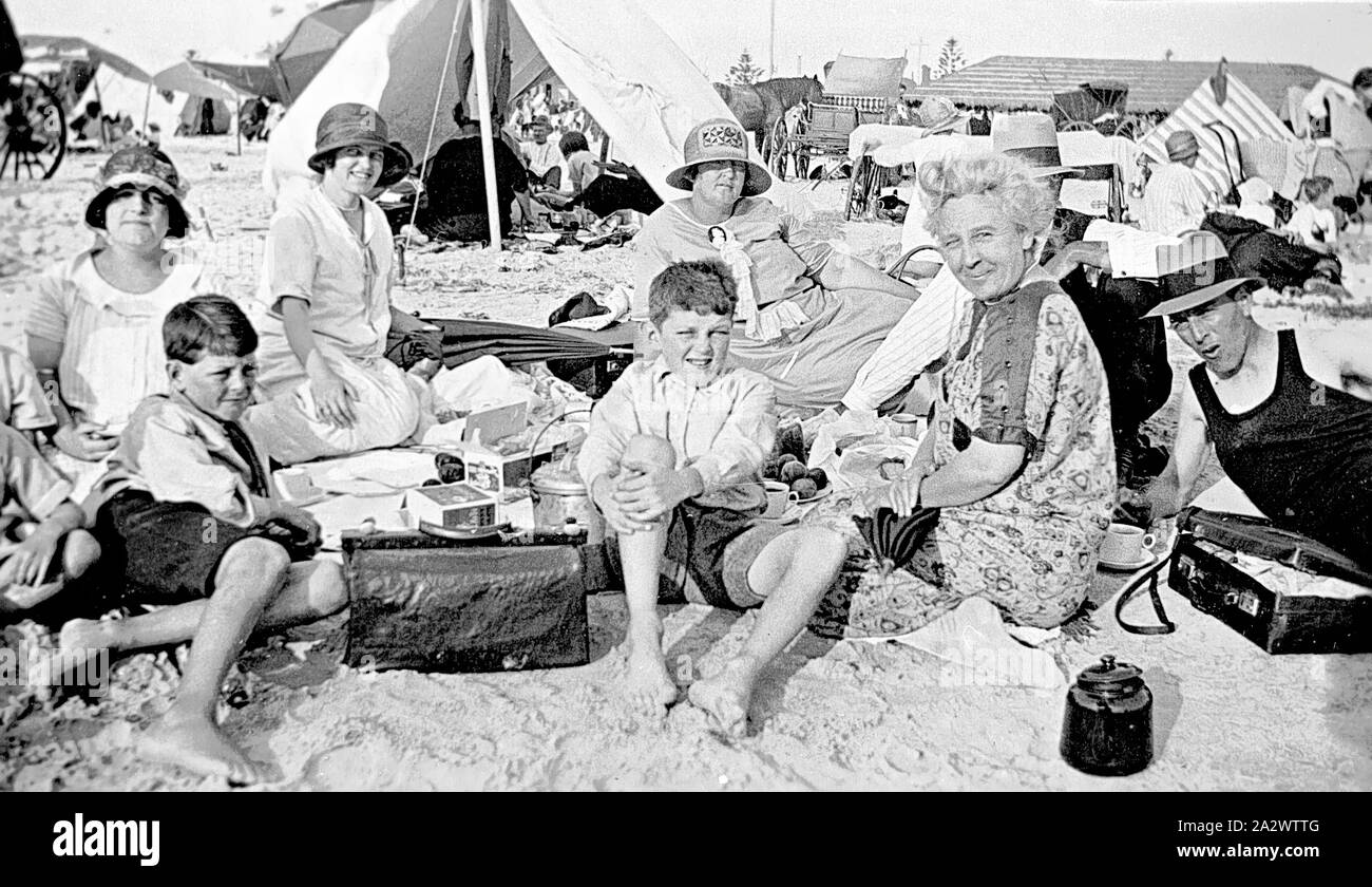 Negativo - Glenelg, Sud Australia, circa 1925, una famiglia picnic sulla spiaggia di Glenelg. Ci sono carrelli A cavalli e tende in background Foto Stock