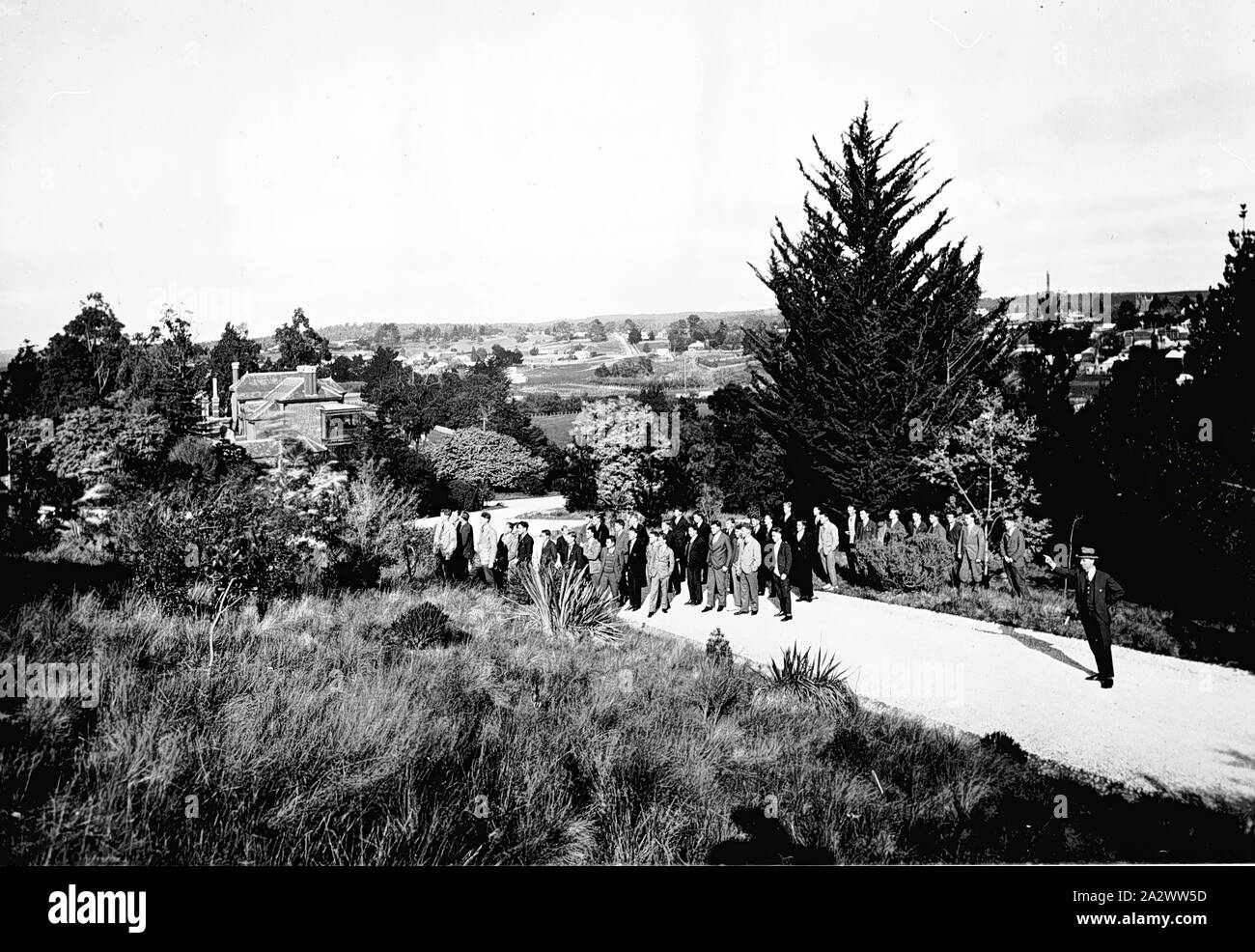 Negativo - Creswick, Victoria, 1927, un gruppo di studenti di selvicoltura. La maggior parte stare su una strada con un paio di dietro. Un uomo sulla destra è rivolta verso qualcosa di fuori del gruppo Foto Stock