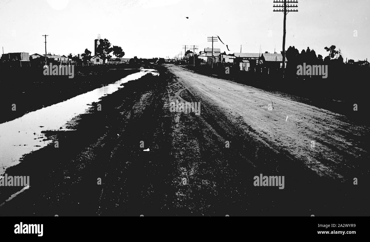 Negativo - Patchewollock, Victoria, del 1940 circa, la strada di ingresso Patchewollock. Vi è un pieno di acqua del fossato a sinistra Foto Stock