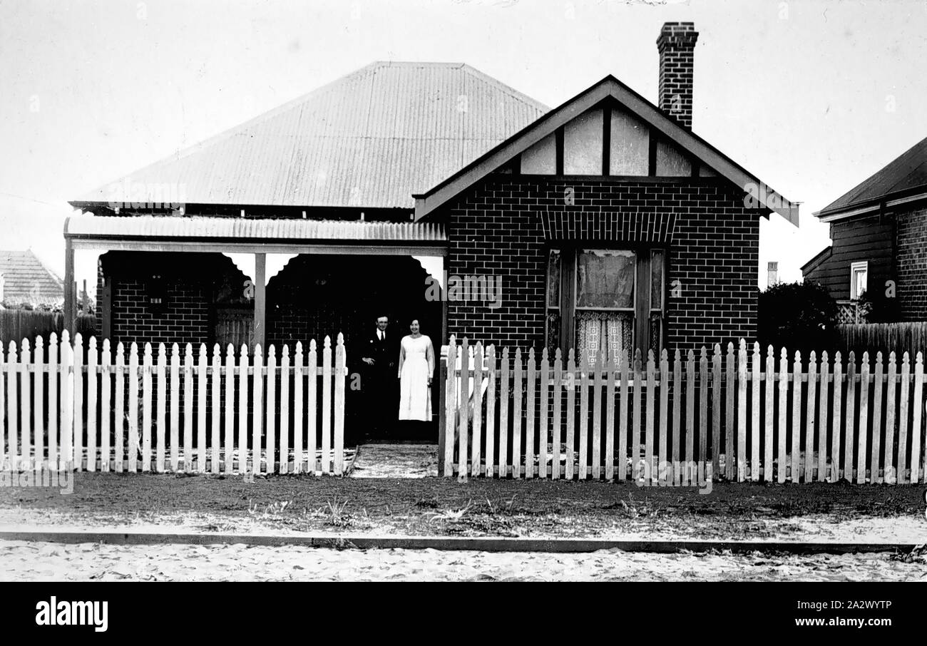 Negativo - Subiaco, Western Australia, circa 1920, la famiglia Congden sulla veranda della loro casa. Si tratta di una casa di mattoni con un ferro corrugato tetto, camino e Picket Fence attraverso la parte anteriore della proprietà Foto Stock