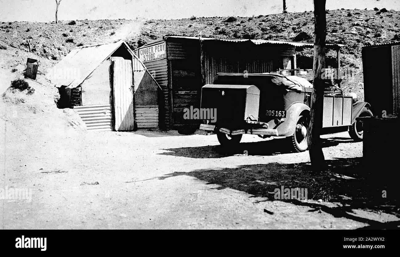 Negativo - Coober Pedy, Sud Australia, 1935, una Ford Tourer Modello B auto di fronte all'Coober Pedy Store. Il negozio è costruito a partire da ferro corrugato Foto Stock