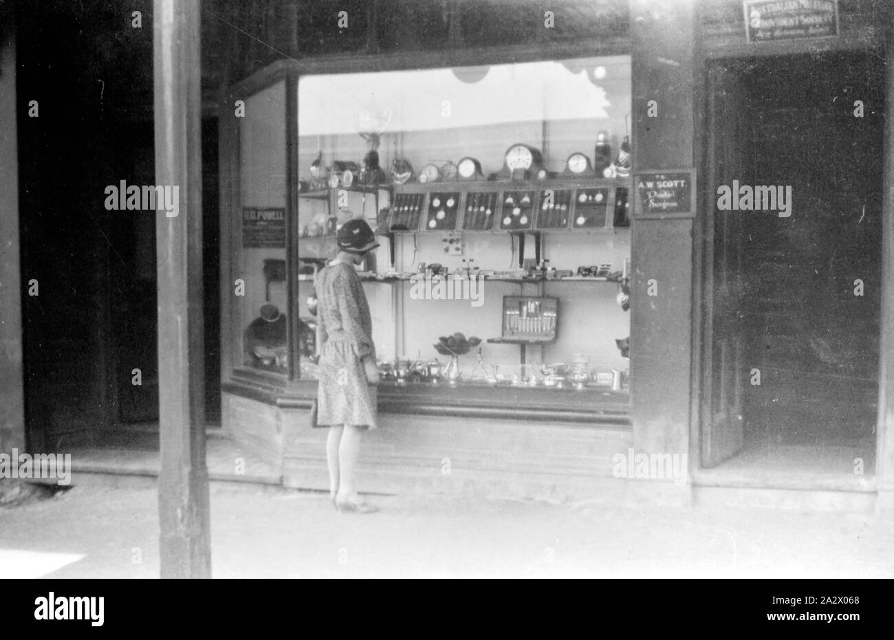 Negativo - Victoria (?), circa 1925, una donna che guarda nella finestra della libreria Powell's orologiaio del negozio. Indossa una lunghezza al ginocchio abito e cloche hat Foto Stock