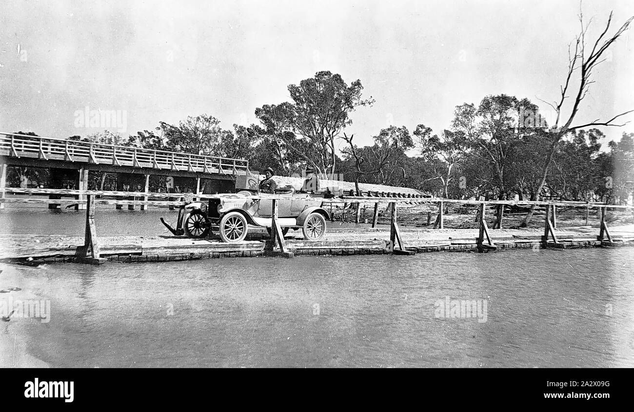 Negativo - Auto sul ponte, Lago di Hindmarsh District, Victoria, 1920, due ponti sul torrente di uscita. Il vecchio ponte in primo piano è al livello di acqua e porta un motore auto. Il nuovo ponte, in background viene costruito superiore su piloni Foto Stock