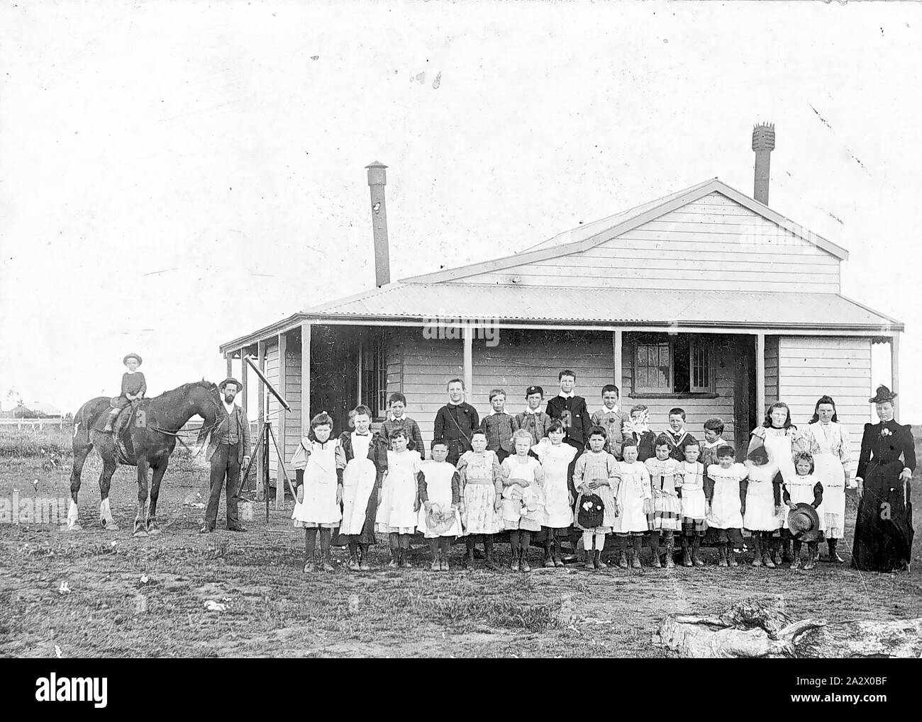 Negativo - insegnante e gli studenti al di fuori del primo Tragowel scuola, Victoria, 1894, l'insegnante e gli studenti al di fuori della prima scuola Tragowel. La scuola è diventata una abitazione privata dopo una nuova scuola è stata costruita. Vi è un piccolo bambino a cavallo sulla sinistra e un telescopio e treppiede accanto a lui Foto Stock