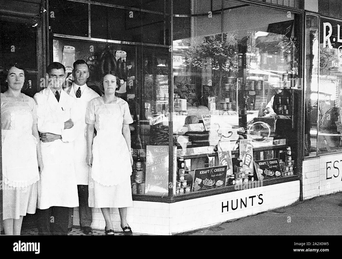 Negativo - Bendigo, Victoria, circa 1935, personale alla porta di Hunt negozio di generi alimentari. "Formaggio Kraft' è pubblicizzato nella vetrina del negozio Foto Stock