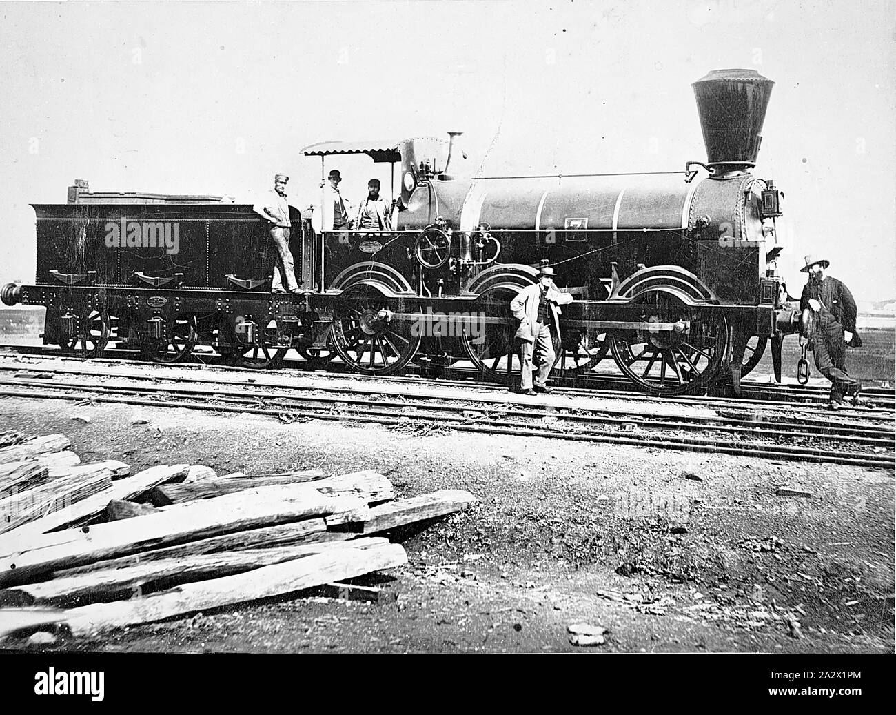 Negativo - Victoria, circa 1865, uomini stavano in piedi su e accanto al P-class 0-6-0 tipo di locomotiva a vapore No.7. Gli uomini erano probabilmente il personale delle ferrovie, compreso un loco equipaggio. Un mucchio di traversine ferroviarie compaiono in primo piano. No.7 è stata una locomotiva merci costruito dalla Beyer Peacock, Manchester nel 1859 Foto Stock
