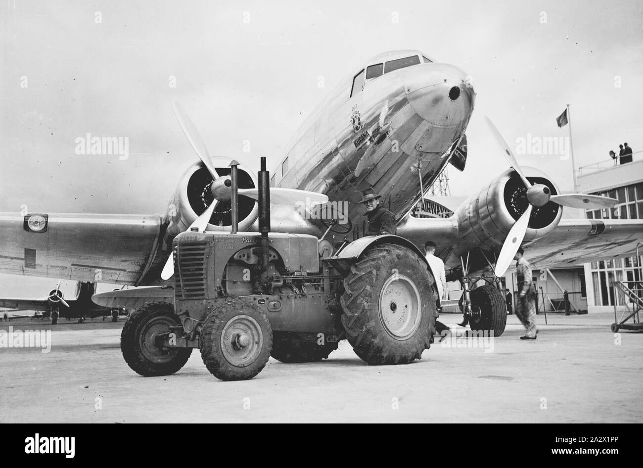 Fotografia - H.V. McKay Massey Harris, attrezzature agricole e di produzione di prove di campo, Essendon, Victoria, Aug 1939, Massey-Harris "pacemaker" il trattore utilizzato dal dipartimento dell'Aviazione Civile a Essendon aeroporto, Vic. Douglas DC 3 aeromobili in background Foto Stock