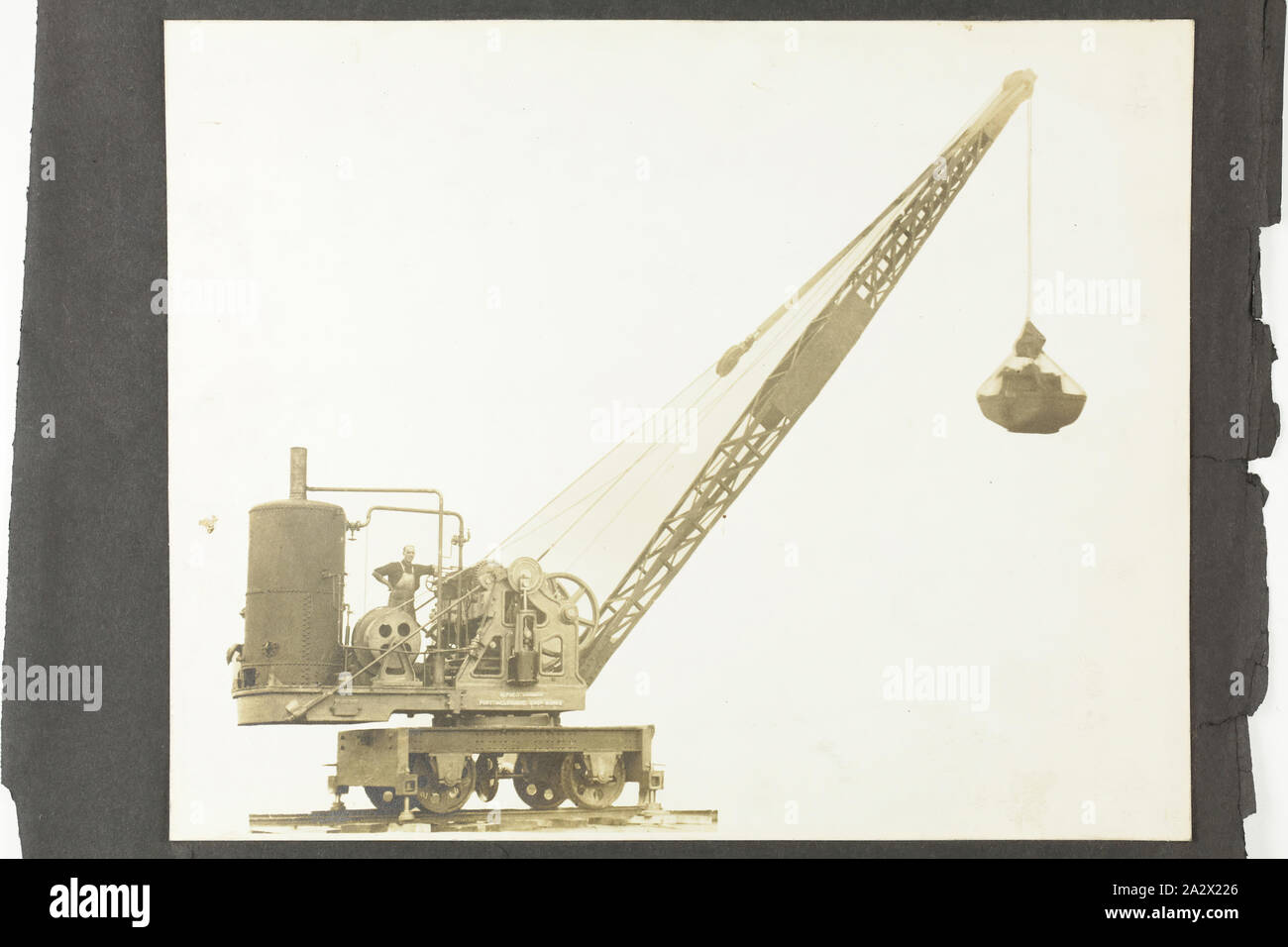 Fotografia - A.T. Harman & Sons, vista di lato di un escavatore Rail-Mounted, circa 1923, una fotografia in bianco e nero attaccato ad una pagina di album. Parte di un gruppo di cinque pagine di album e allentato tre fotografie che ritraggono escavatori, verricelli e altre apparecchiature industriali fabbricati da A.T. Harman & Sons. Parte di una collezione di fotografie, film, disegni tecnici, la letteratura specializzata e i documenti aziendali relativi alle operazioni del Vittoriano studio di ingegneria A.T. Harman & Figli Foto Stock