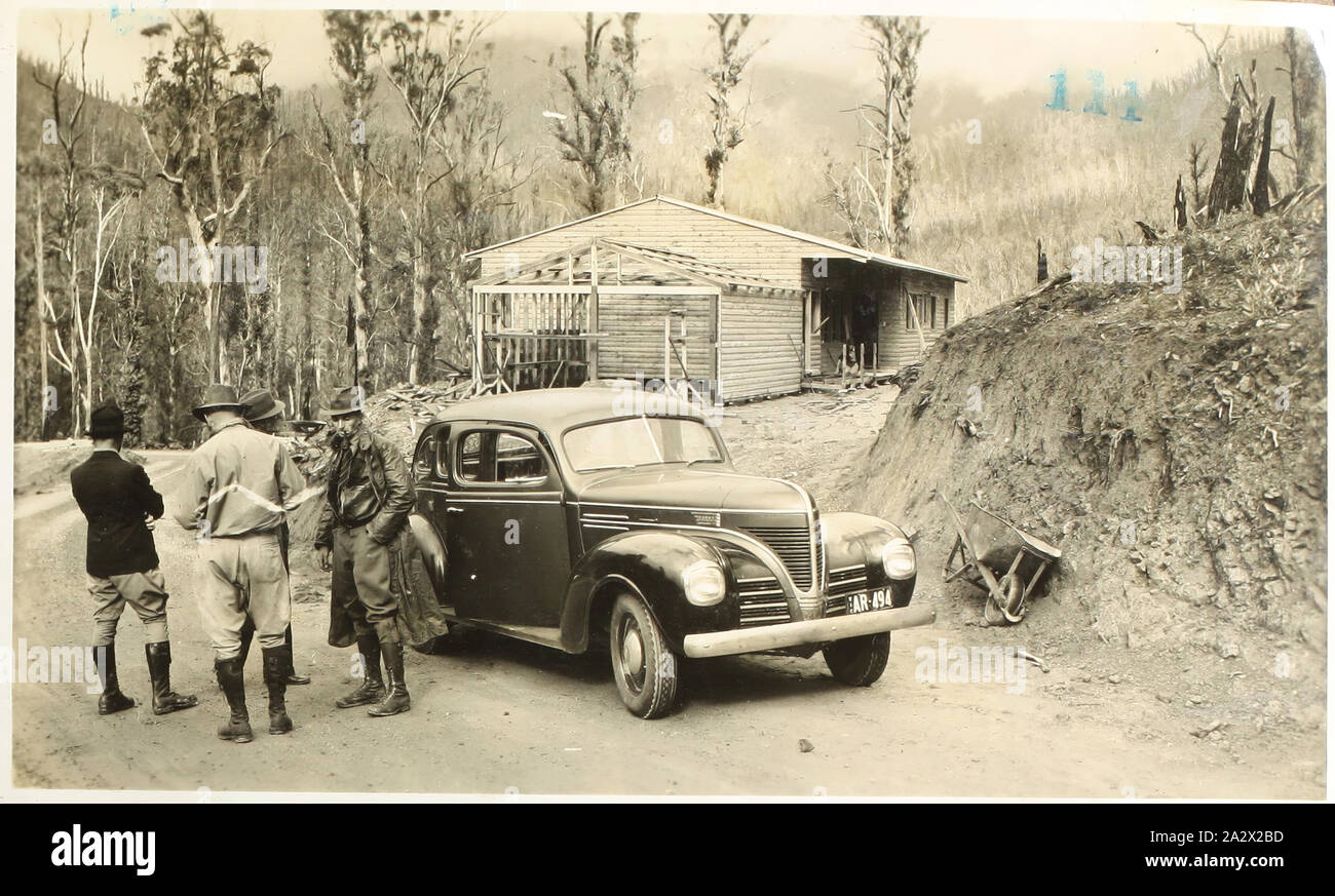 Fotografia - Membro Commissione dell'energia elettrica, motore Dodge auto & Costruzione in legno, Kiewa Valley, Victoria, circa 1940, fotografia in bianco e nero di quattro uomini e una Dodge auto di fronte un parzialmente costruito edificio in legno nella valle Kiewa, circa 1940. Esso fa parte di una grande collezione fotografica di una lastra di vetro e la pellicola di negativi e stampe fotografiche e album fotografici, relative allo sviluppo della alimentazione elettrica industria in Victoria, azionato dal membro della Commissione di elettricità di Victoria (SECV Foto Stock