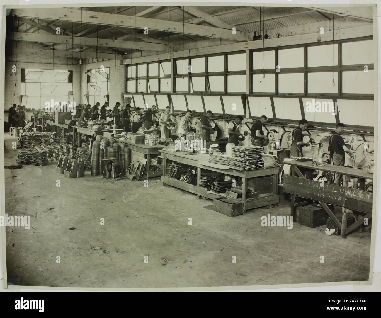 Fotografia - Hecla Electrics Pty Ltd, lavoratori in fabbrica la lucidatura di bollitori, 1920s, la fotografia in bianco e nero di Hecla lavoratori in fabbrica nella divisione di lucidatura di Hecla della fabbrica di Melbourne, eventualmente il Little Bourke Street sito. Questa fotografia è da un album contenente 255 fotografie in bianco e nero raffiguranti gli elettrodomestici, showroom visualizza, interni di fabbrica e materiale pubblicitario relative a Hecla Electrics Pty Ltd. È parte della collezione Hecla di Foto Stock