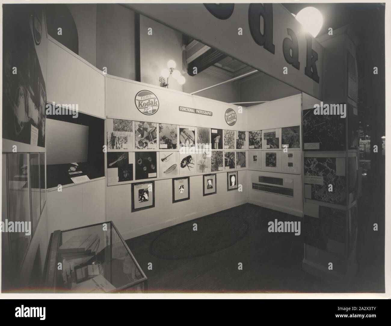 Fotografia, Stand fieristico, 'funzionale fotografia", industrie chimiche Exposition, Sydney, Sep 1938, fotografia in bianco e nero di un Kodak Australasia Pty Ltd 'fotografia funzionale' exhibition display stand o fiera stand alle industrie chimiche esposizione tenutasi a Sydney nel settembre 1938. Vi è un vetro mobile in corrispondenza di una estremità piena di materiali fotografici chimici, così come uno schermo televisivo impostato nella parete e fotografie disposte intorno a tutte e tre le pareti e l'uscio pilastro Foto Stock