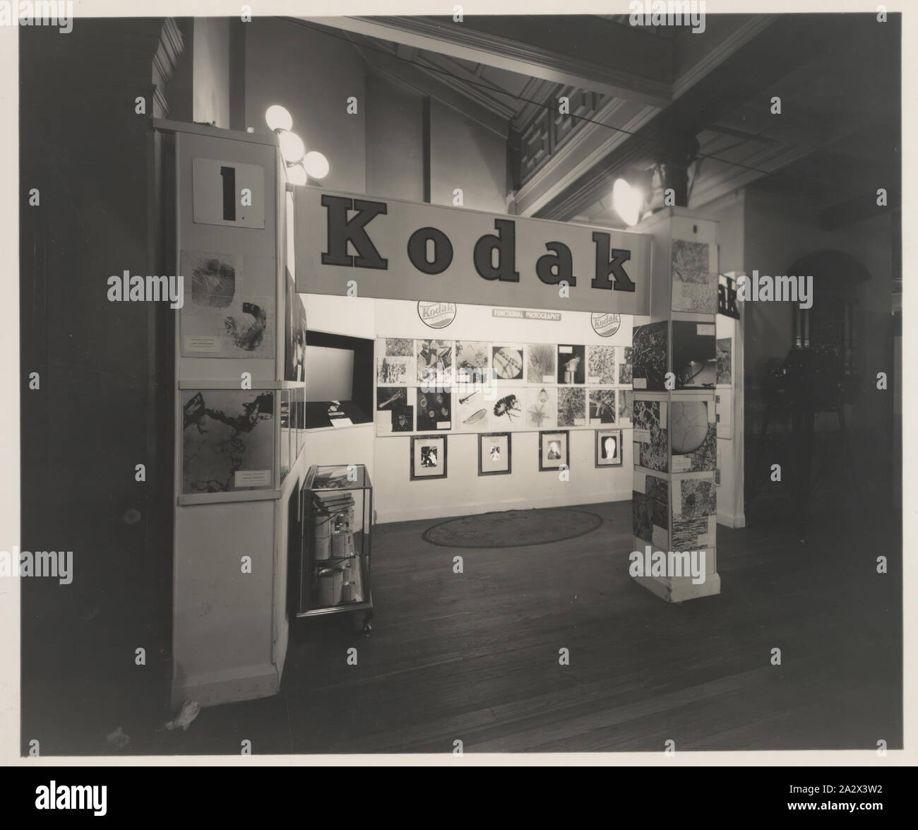 Fotografia, Stand fieristico, 'funzionale fotografia", industrie chimiche Exposition, Sydney, Sep 1938, fotografia in bianco e nero di un Kodak Australasia Pty Ltd 'fotografia funzionale' exhibition display stand o fiera stand alle industrie chimiche esposizione tenutasi a Sydney nel settembre 1938. Si tratta di un angolare, vista laterale del supporto. Vi è un vetro mobile in corrispondenza di una estremità dello schermo pieno di materiali fotografici chimici, così come uno schermo di proiezione impostata nella parete e fotografie disposte Foto Stock