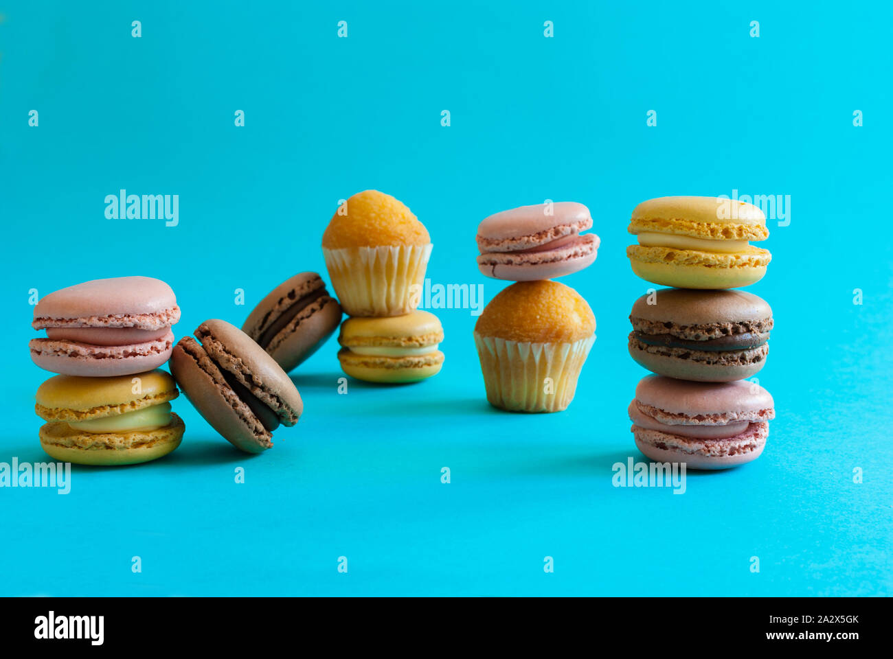 Macarons e muffin su uno sfondo blu completamente integrate tra di loro Foto Stock