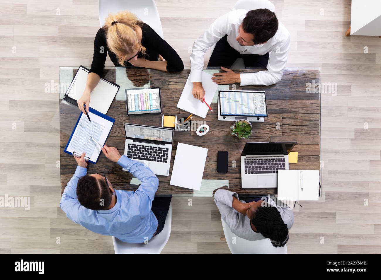 Elevato angolo di visione di un team di dirigenti aziendali discutendo sui dati in Sala Riunioni Foto Stock